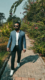 Full length of young man standing on footpath