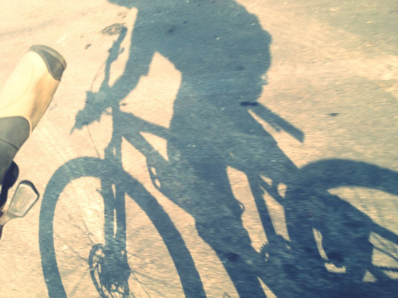 transportation, street, high angle view, road marking, road, shadow, bicycle, asphalt, sunlight, land vehicle, mode of transport, communication, focus on shadow, day, outdoors, unrecognizable person, text, guidance