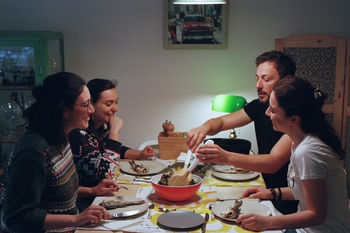 Happy friends having dinner at home