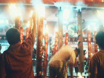 People on illuminated street at night