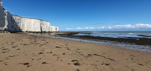 Scenic view of beach against clear blue sky