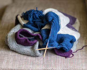 Picture with knitted sweater, knitting needles and yarn, close-up view