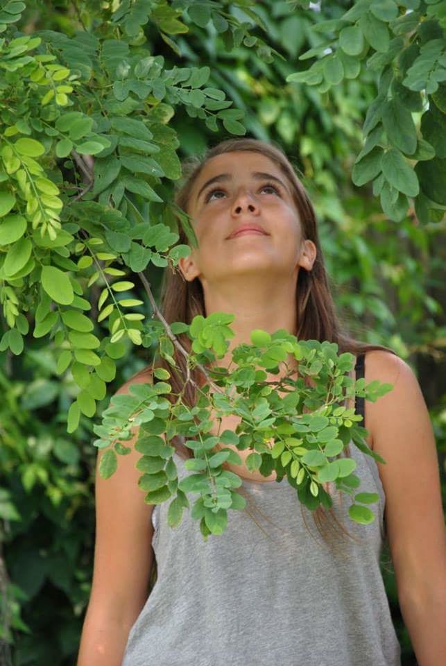 lifestyles, leaf, portrait, plant, green color, person, young adult, looking at camera, growth, leisure activity, casual clothing, young women, front view, waist up, standing, tree, smiling, nature