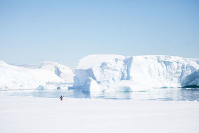 Frozen lake against clear sky during winter