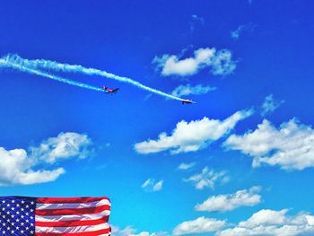 Low angle view of airshow against blue sky