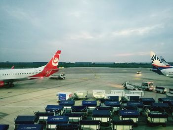 Airplane on airport runway against sky