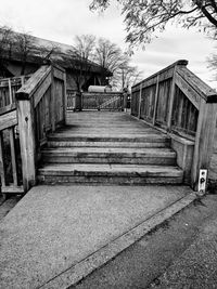 Steps amidst houses against sky