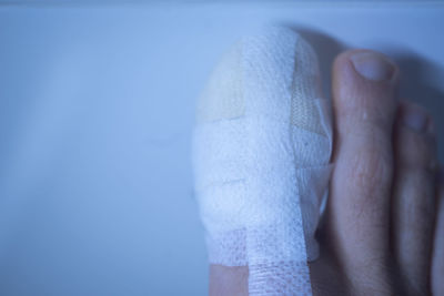 Close-up of hands against blue wall