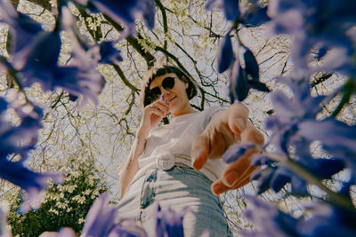 Low angle view of woman walking on flowering plant