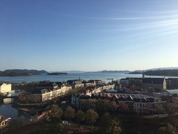 High angle view of townscape by sea against sky