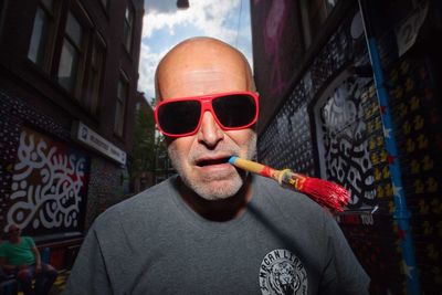 Portrait of man smoking cigarette in city