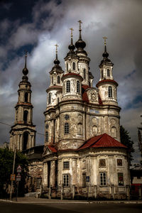Low angle view of bell tower against cloudy sky