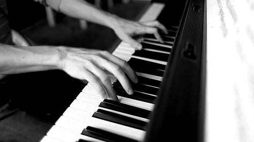 Close-up of hands playing piano