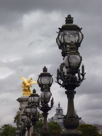 Statue of street light against cloudy sky