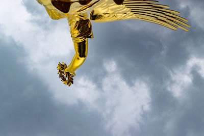 Low angle view of yellow flag against sky