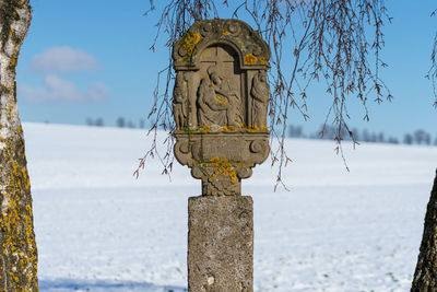 Close-up of wooden post by sea against sky