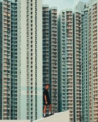 Full length of man standing on skyscrapers in city