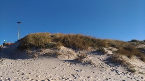 Panoramic shot of desert against clear blue sky