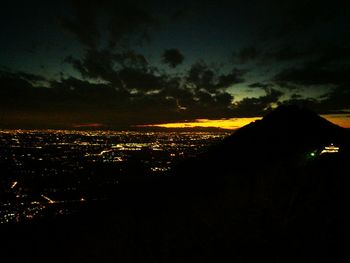 Illuminated cityscape against sky at night