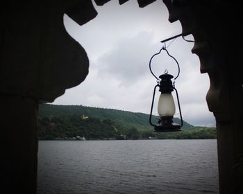 Close-up of electric lamp hanging over sea