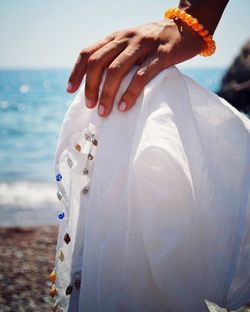 Cropped hand holding cloth at beach