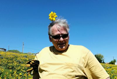 Low angle view of man standing against clear blue sky