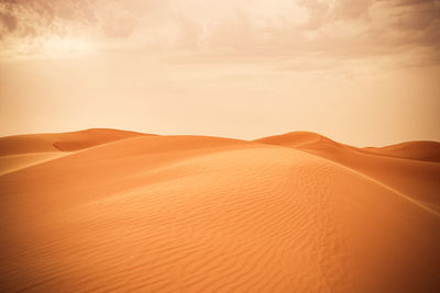 Scenic view of desert against sky during sunset