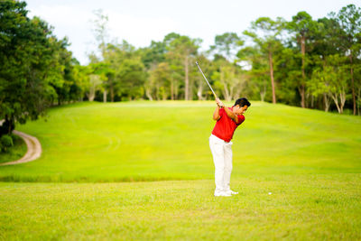 Full length of man playing on golf course