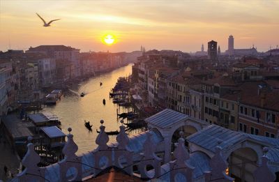 High angle view of city buildings against sky during sunset
