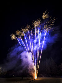 Low angle view of firework display at night