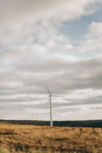 Windmill on field against sky