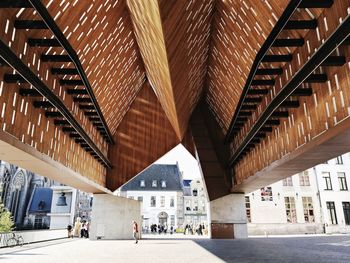 People walking under an art structure in the city of gent