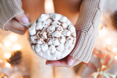 Woman hands holding a cup of coffee. cozy winter concept. hot chocolate or cocoa with marshmallow