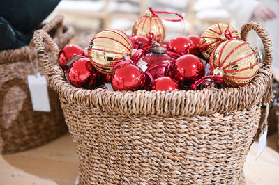 A basket with christmas tree toys in the store. red and gold balls