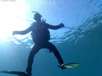 Low angle view of mid adult man swimming underwater in sea