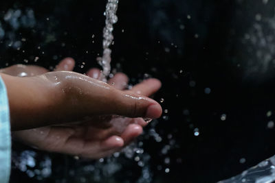 Cropped image of hand splashing water