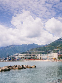 Scenic view of lake by buildings against sky