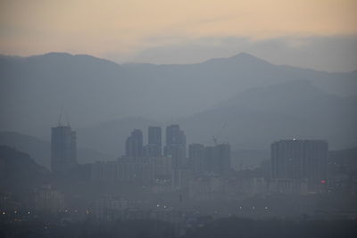 Buildings in city during fog