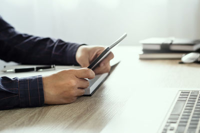 Midsection of man using laptop on table
