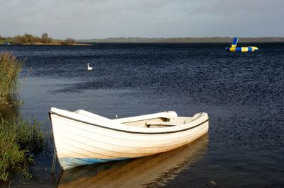 Sailboat moored on sea against sky