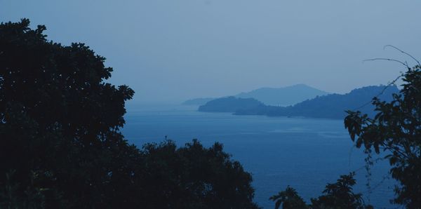 Scenic view of sea and mountains against clear sky