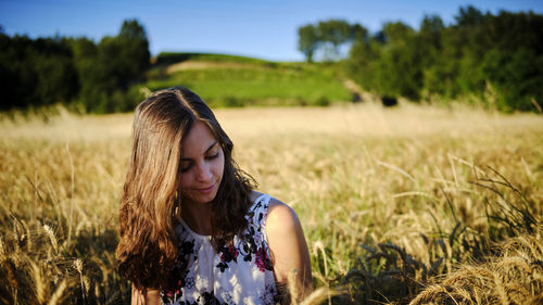 Young woman wearing sunglasses on field against sky