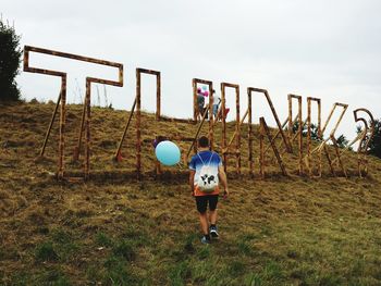 Man with balloon walking on field