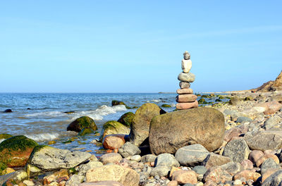 Stack of pebbles on beach against sky