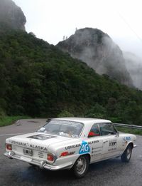 Car on road by mountain against sky