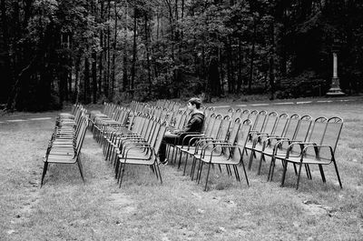 Empty chairs against trees on landscape