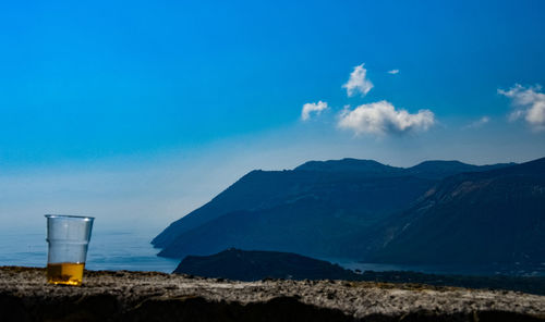 Scenic view of land and mountains against blue sky