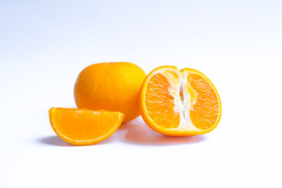 Close-up of orange fruit against white background