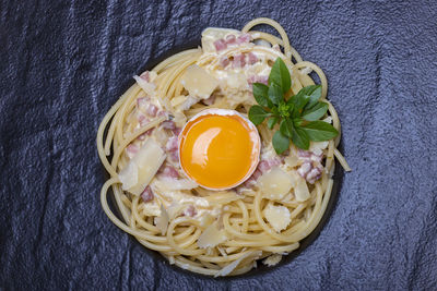 High angle view of spaghetti and egg yolk served on slate