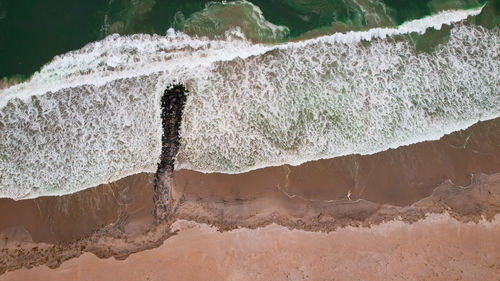 Aerial view of waves breaking on shore